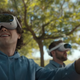 A man wearing a Pico 4 headset stares to the side sitting next to another man wearing a VR headset